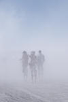 People on stilts during a dust storm