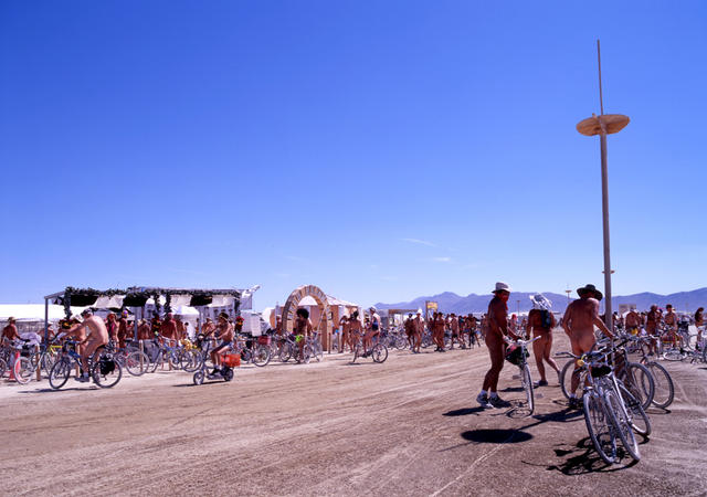 A whole lot of nude men on bicycles