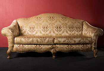 Gold Brocade Couch on Red Wall Background